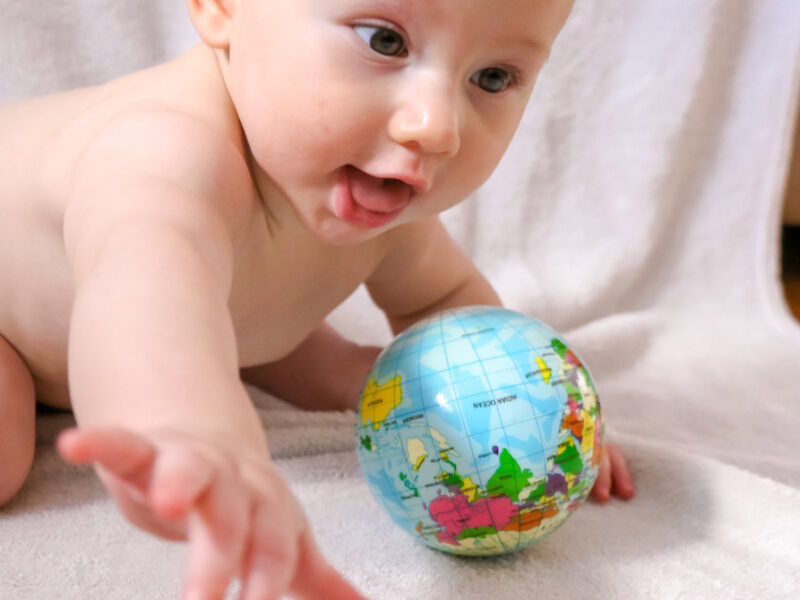 Baby with toy globe of planet Earth
