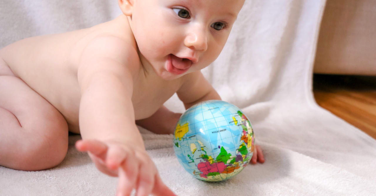 Baby with toy globe of planet Earth