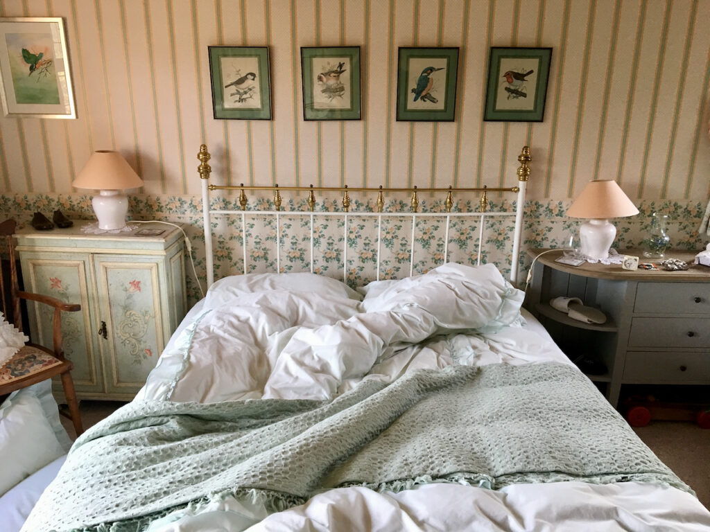 Unmade double bed in country home on English countryside