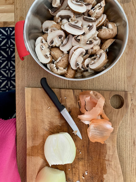Dairy-free mushroom soup prep: photo of sliced cremini mushrooms in a bowl 