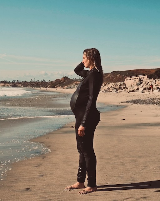 Pregnant woman standing by ocean